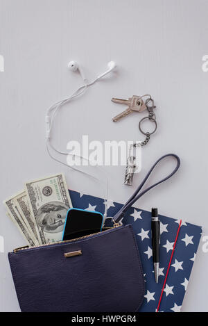 High angle view of US paper currency with various objects on white table Stock Photo