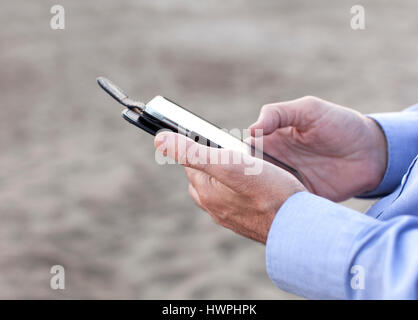 A businessman sends a message with a mobile phone. Stock Photo