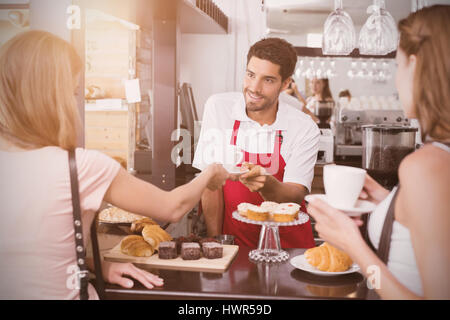 Graphic image of flare against friends with male barista at counter in coffee shop Stock Photo