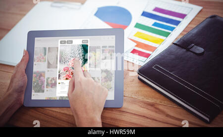 Composite image of flower image on website against over shoulder view of hipster woman using tablet Stock Photo