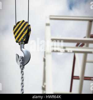 Studio Shoot of a crane lifting hook against low angle view of scaffolding against cloudy sky Stock Photo