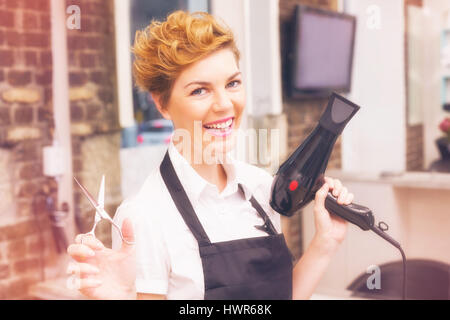 Graphic image of flare against confident hairdresser at work in hair salon Stock Photo
