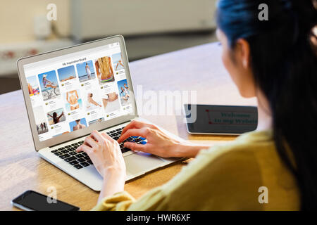 Composite image of website page against businesswoman using a laptop Stock Photo