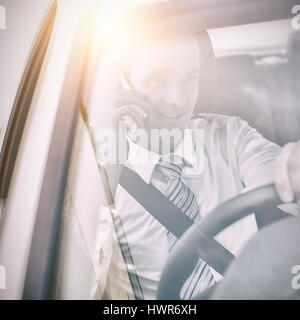 Man driving a car and using his phone Stock Photo