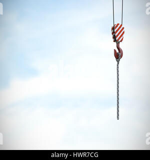 Studio Shoot of a crane lifting hook against blue sky with clouds Stock Photo