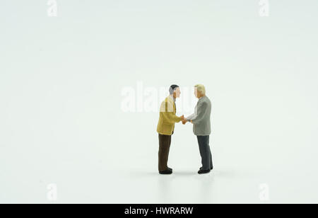 two mini businessman shake hand on isolate background - can use to display or montage on products Stock Photo