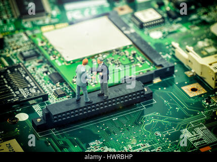 mini two businessman make a deal on motherboard for commitment about technology world - can use to display or montage on products Stock Photo