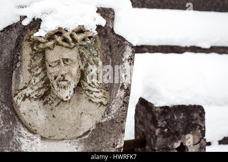 Face of Jesus Christ on old tombstone in winter Stock Photo