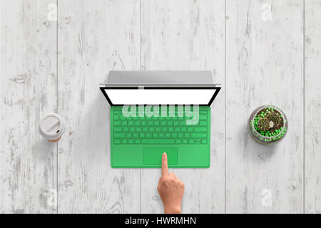 Green laptop with white isolated screen on white wooden desk. Top view scene. Woman hand touch keyboard. Coffee and plant beside. Free space for text. Stock Photo