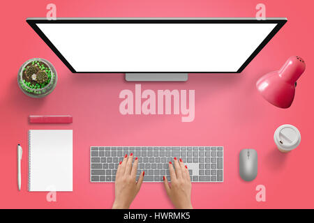 Red surface with computer monitor, keyboard and mouse. Isolated blank screen for mockup. Plant, lamp, coffee, pad, pencil, marker beside. Free space i Stock Photo
