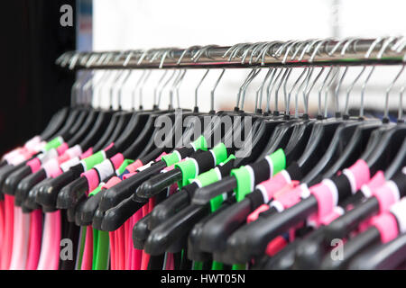 Assorted fluorescent color dresses on hangers Stock Photo