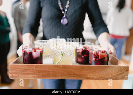Midsection of woman carrying drinks in tray Stock Photo