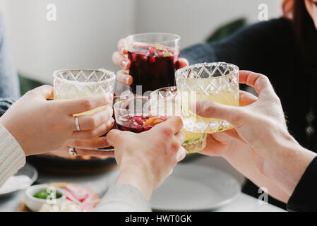 Cropped hands of friends toasting drinks in party at home Stock Photo