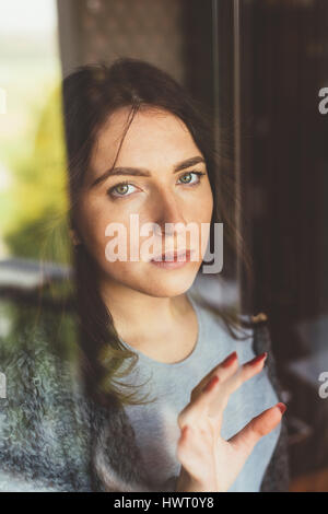 Young beautiful eastern woman seen through window - double exposure, artistic, creative concept Stock Photo