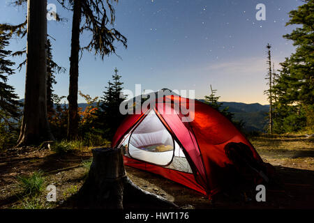 Illuminated tent on field against sky at dusk Stock Photo