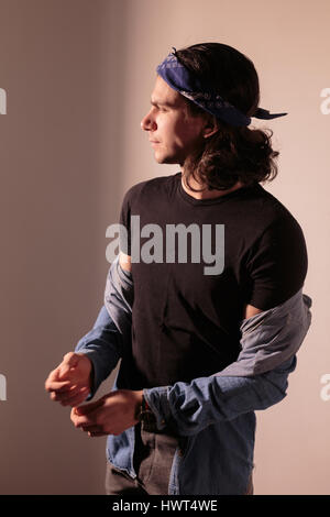 Young man rocker in bandana with long hair. Stock Photo