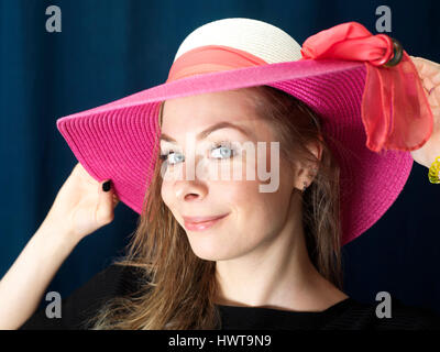 Studio portrait of a young woman in a good mood wearing red hat Stock Photo