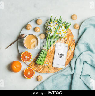 Coffee, cookies, oranges, flowers, mobile phone with word Wake Up Stock Photo