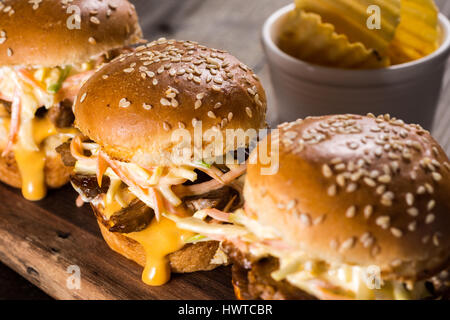 Homemade Mini Beef Burgers with Coleslaw Salad on Little Wooden Cutting Board. Barbecue Meat Sandwiches on Rustic Table. Stock Photo