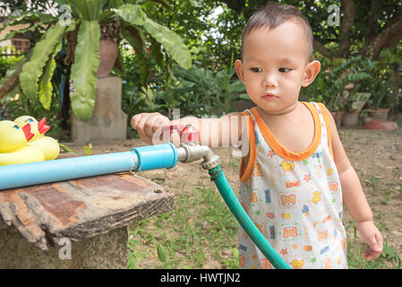 Kid  using hand close faucet to turn off water Stock Photo