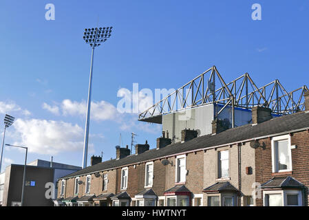 Row of terraced houses and Turf Moor,Burnley football club,Burnley,Lancashire,UK Stock Photo