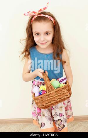 Adorable little girl playing with Easter eggs on spring a day Stock Photo