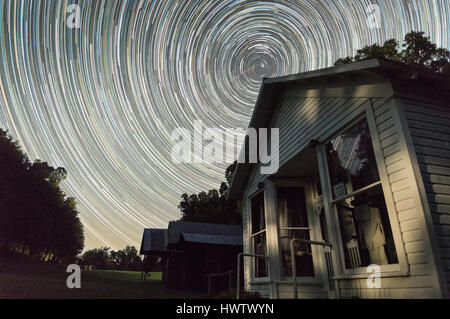 The stars appear to rotate around Polaris, the north star, in a series of stacked exposures over 3 hours with a couple meteors visible. Stock Photo