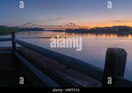 Twilight begins where the Kanawha and Ohio Rivers join from Tu-Endie-Wei park in Point Pleasant as the lights from a small boat rounds the corner. Stock Photo