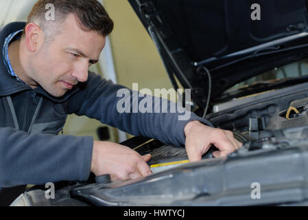 car mechanic uses battery Stock Photo