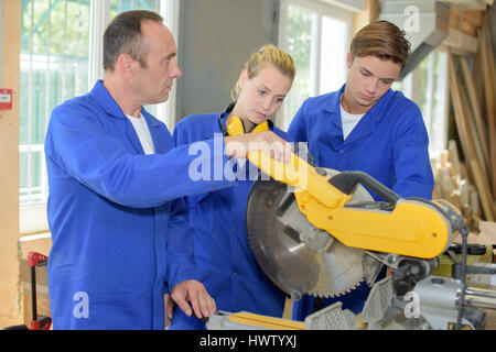Man cutting wood using stationary circular saw outdoors in the sun ...