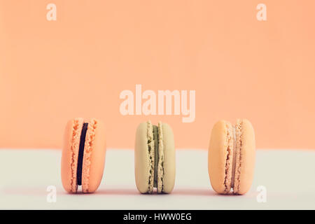 Raw of pastel colors assorted french  macaroons on a colored background.  Copy space for text. Horizontal Stock Photo