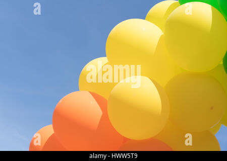 Multi colour balloons in a bunch floating in the sky Stock Photo