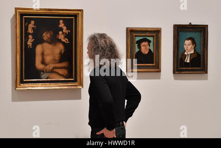 Erfurt, Germany. 23rd Mar, 2017. Kai Uwe Schierz, director of the Art Museums Erfurt at the exhibition 'Cranach before and after the reformation' at the Angermuseum in Erfurt, Germany, 23 March 2017. The paintings (L-R), 'Schmerzensmann zwischen Engeln', 'Bildnis Martin Luthers' and 'Bildnis der Katharina Luther', which were fashioned after Cranach, or produced in his workshop. The exhibition shows rare pictures, partially from private collections, of Lucas Cranach from the 25th March to the 25th June. Photo: Martin Schutt/dpa-Zentralbild/dpa/Alamy Live News Stock Photo