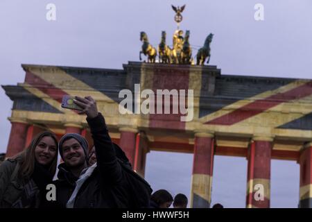 Berlin, Berlin, Germany. 23rd Mar, 2017. People in font of the illuminated Brandenburg Gate (German: Brandenburger Tor) in Central Berlin. Germany's famous Brandenburg Gate is lit up with the colors of the Union Jack one day after a presumed terrorist attack in London, where at least four people were killed. Several pedestrians struck by a car on Westminster bridge, a police officer was stabbed in the Houses of Parliament by an attacker, who was shot by police. Credit: Jan Scheunert/ZUMA Wire/Alamy Live News Stock Photo