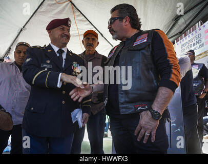 Tijuana, Baja California, Mexico. 18th Mar, 2017. HECTOR BARAJAS, 40, left, a veteran of the U.S. 82nd Airborne, thanks BANDIT, the leader of a motorcycle group called the Vet Hunters MC, who rode down from Los Angeles to join Barajas and other deported veterans in Tijuana Saturday, and present them a donation of cash collected among their members.A gathering of about 20 veterans living in Tijuana who fought for branches of the U.S. military and were deported after being discharged from service, welcomed supporters Saturday at their ''bunker'' outpost. A representative from Arizona Congress Stock Photo