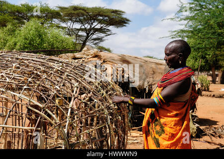 SOUTH HORR, KENYA - JULY 07: African woman  with characteristic decorative necklaces from the Samburu tribe in the traditional dress he is building hi Stock Photo