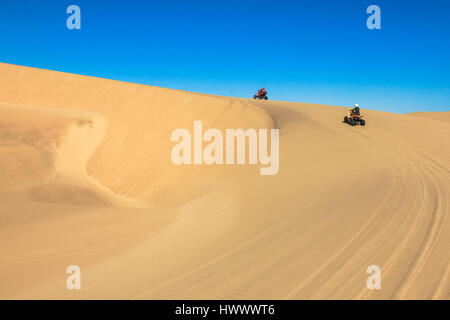 Quad driving people - two happy bikers in sand desert. Stock Photo