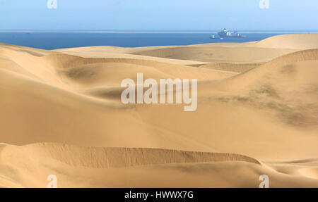 Big sand dunes. Ocean with ships and boat in background. Stock Photo