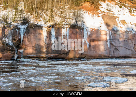 frozen river in winter with sandstone cliffs and ice blocks. Gauja National Park. Latvia. Stock Photo