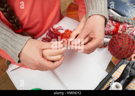 mother teaching daughter girl knit, top view, sewing accessories top view, seamstress workplace, many object for needlework, handmade and handicraft Stock Photo