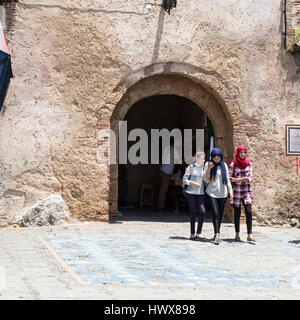 Chefchaouen, Morocco.  Young Moroccan Women Exiting the Medina through the Bab El-Ain, Wearing Modern Stylish but Conservative Clothing. Stock Photo