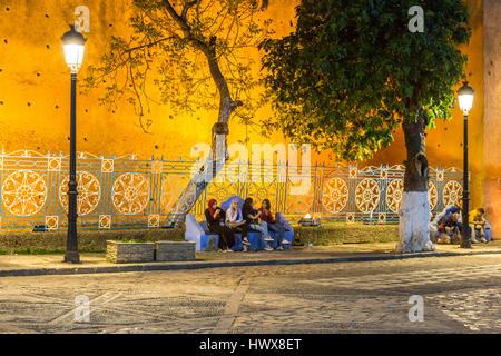 Chefchaouen, Morocco.  Women Talking on a bench, Place Outa El-Hammam, Night. Stock Photo