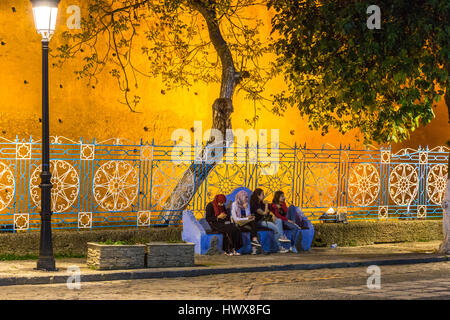 Chefchaouen, Morocco.  Women Talking on a bench, Place Outa El-Hammam, Night. Stock Photo