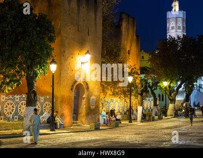 Chefchaouen, Morocco.  People Relaxing in the Place Outa El-Hammam in the Evening.  Entrance to the Kasbah, Built 1471. Stock Photo