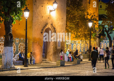 Chefchaouen, Morocco.  People Relaxing in the Place Outa El-Hammam in the Evening.  Entrance to the Kasbah, Built 1471. Stock Photo