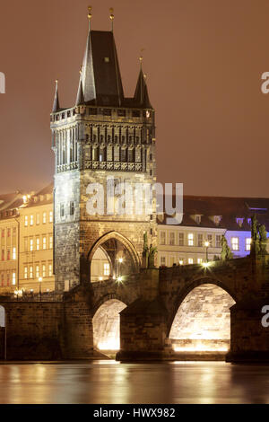 Lesser town tower on Charles bridge at night in Prague.
