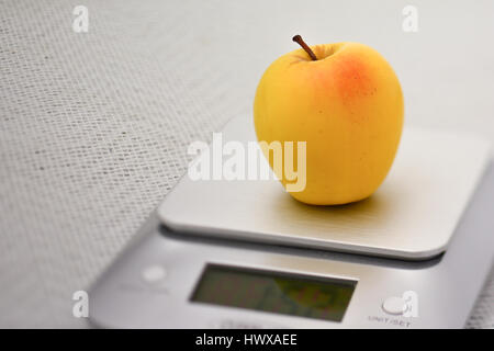 Weighing an Apple Fruit on a Digital Kitchen Scale in Grams on