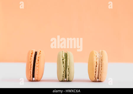 Raw of pastel colors assorted french  macaroons on a colored background.  Copy space for text. Horizontal Stock Photo