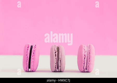Assorted pink and purple french macaroons on a colored background. Copy space for text. Horizontal Stock Photo