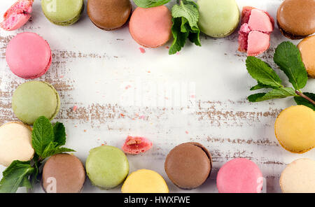 Colorful Macaroons with mint on a  white wooden table. Top view Stock Photo